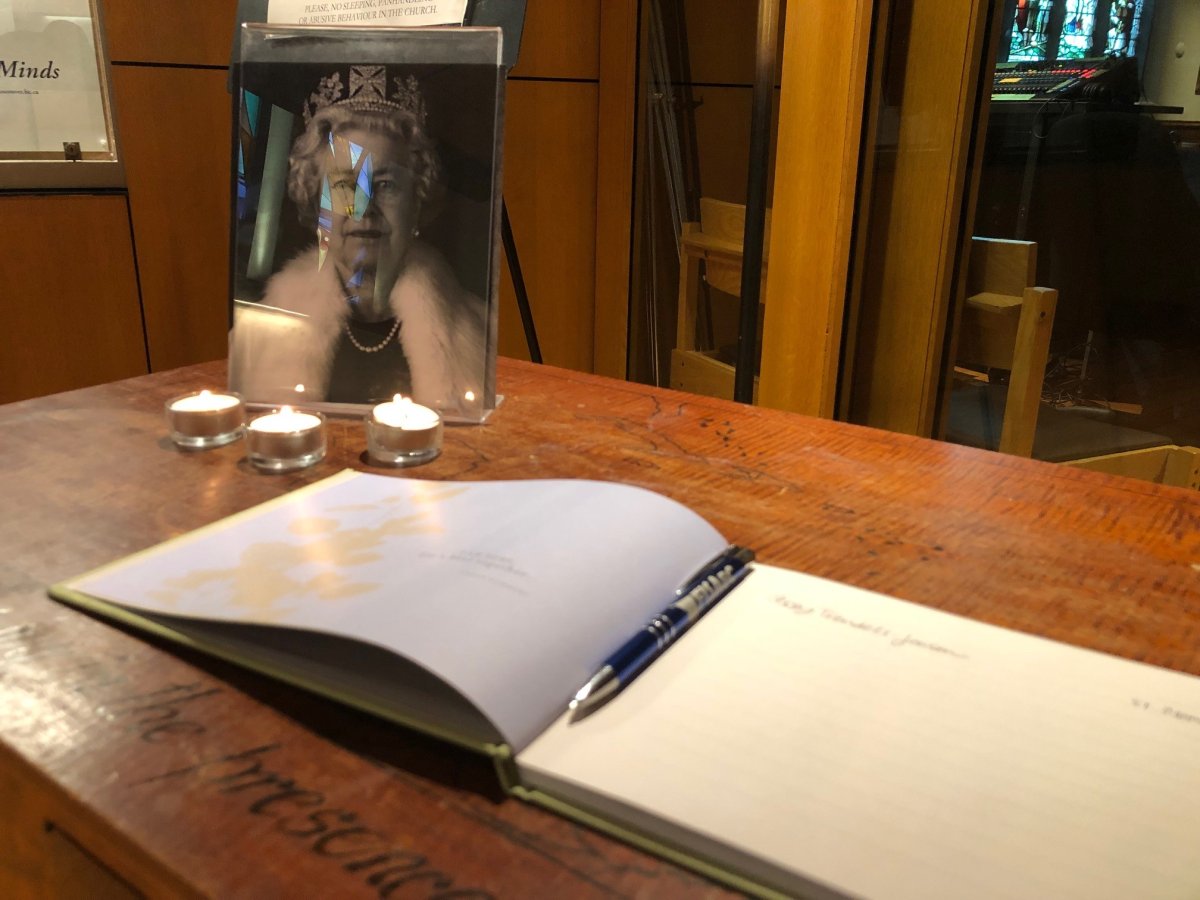 A photo of Queen Elizabeth II and a book for memories and condolences is laid out at the Christ Church Cathedral in Vancouver on Thurs. Sept. 8, 2022, hours after the Queen passed away at her Scotland residence.