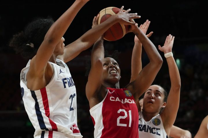 Canada's Nirra Fields, centre, attempts to shoot at goal as France's Marieme Badiane, left, blocks her shot during their game at the women's Basketball World Cup in Sydney, Australia, Friday, Sept. 23, 2022. 