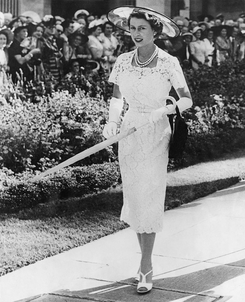 Queen Elizabeth II wears a slim-fitting white lace dress to a garden party in Sydney, Australia, before leaving for Tasmania on the liner 'SS Gothic', February 1954.