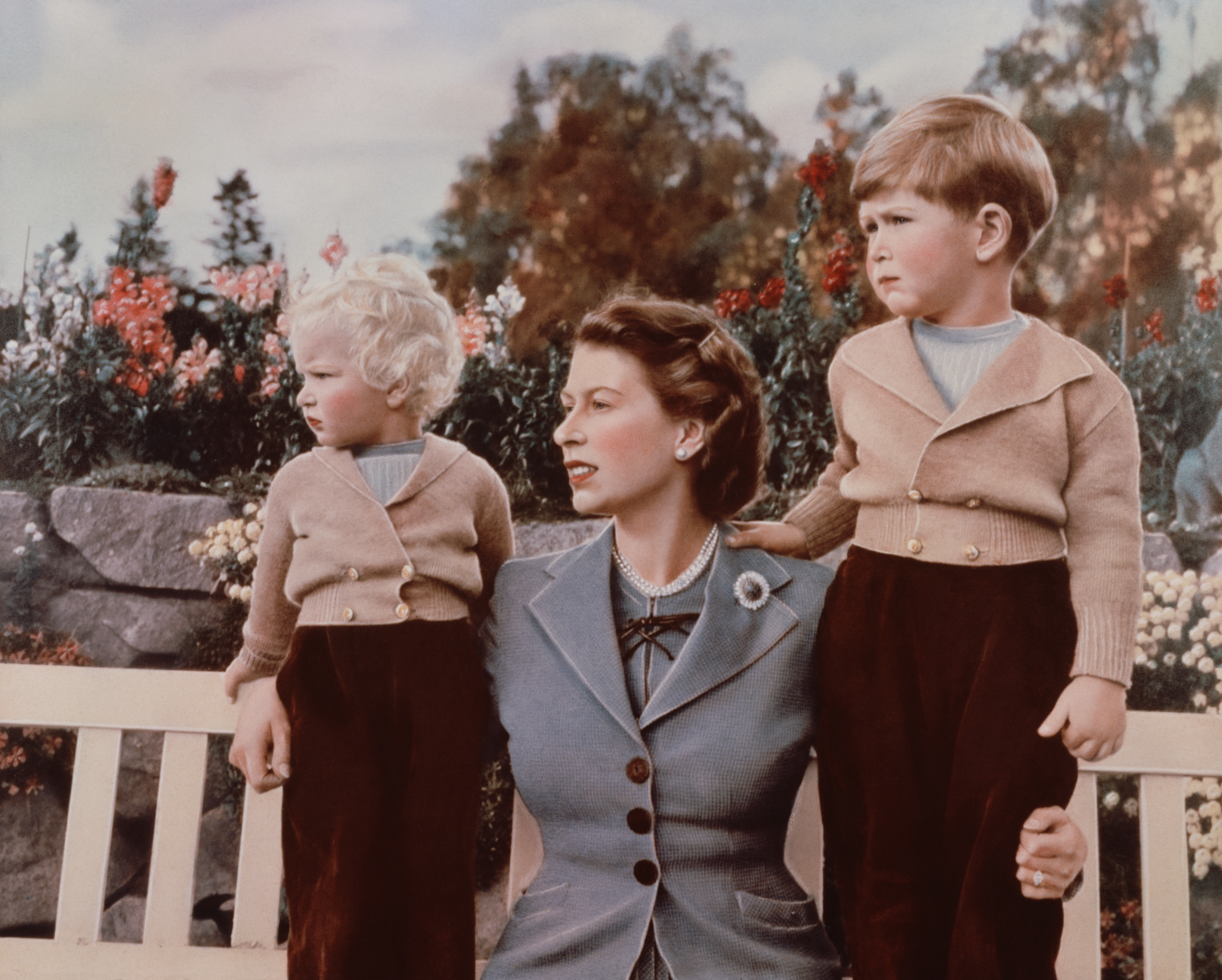 September 1952: Queen Elizabeth II with Prince Charles and Princess Anne in the grounds of Balmoral Castle, Scotland. Charles is celebrating his 4th birthday.