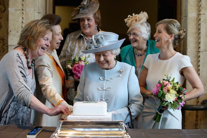 Sophie, Countess of Wessex and Princess Anne, Princess Royal, look on as Queen Elizabeth II cuts a Women's Institute Celebrating 100 Years cake at the Centenary Annual Meeting of The National Federation of Women's Institute at Royal Albert Hall at the Royal Albert Hall on June 4, 2015, in London, England.