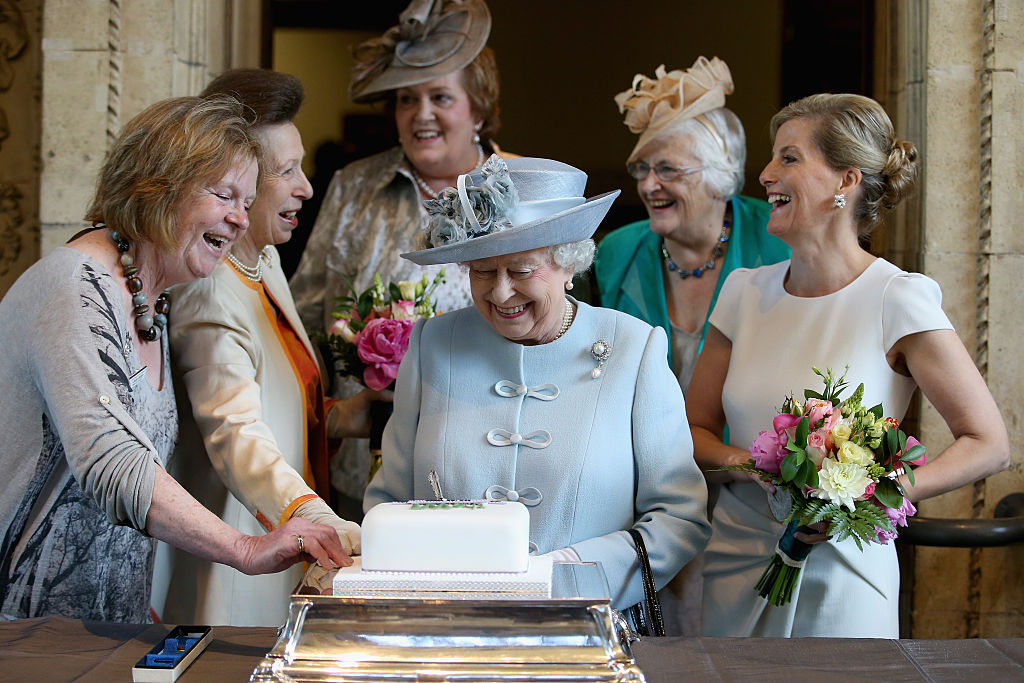 Sophie, Countess of Wessex and Princess Anne, Princess Royal look on as Queen Elizabeth II cuts a Women's Institute Celebrating 100 Years cake at the Centenary Annual Meeting of The National Federation Of Women's Institute at Royal Albert Hall at the Royal Albert Hall on June 4, 2015 in London, England.