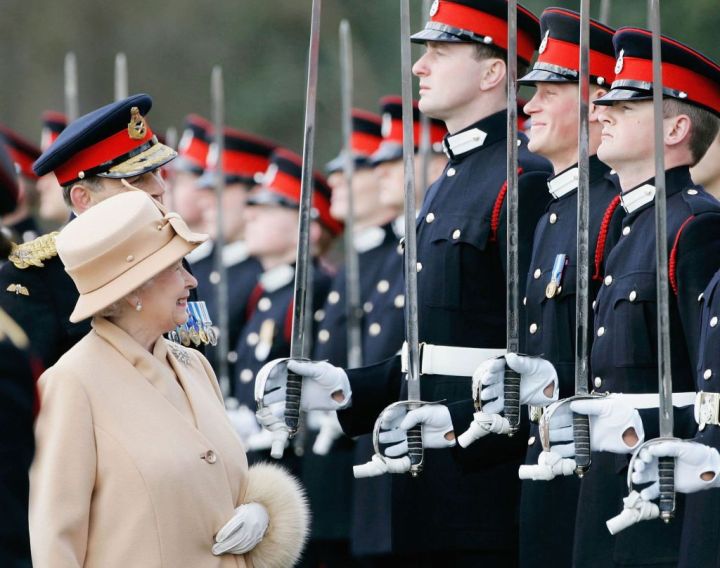 Queen Elizabeth II as proud grandmother smiles at Prince Harry as she inspects soldiers at their passing-out Sovereign's Parade at Sandhurst Military Academy on April 12, 2006, in Surrey, England.