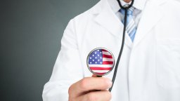 A stock images shows a doctor holding a stethoscope printed with the American flag.