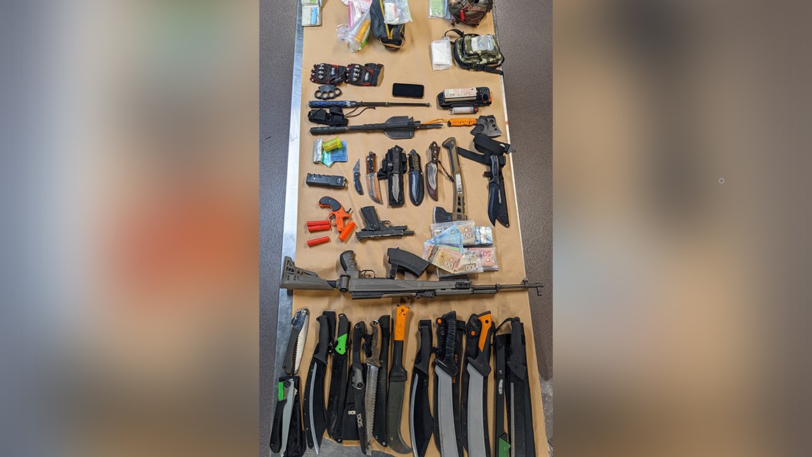 Police say an investigation into a suspicious person report led to a cache of weapons in a homeless camp that doubled as a bike chop shop.
