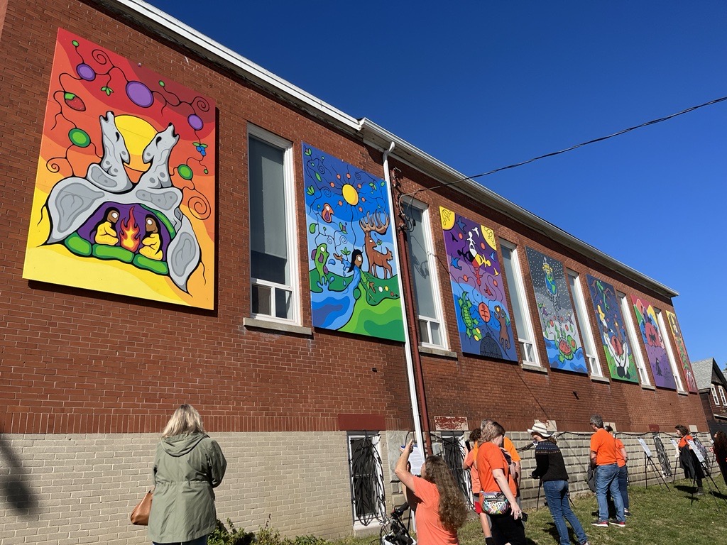 The seven-panel "We Are Still Here" mural sits unveiled on the southern wall of the N'Amerind Friendship Centre.