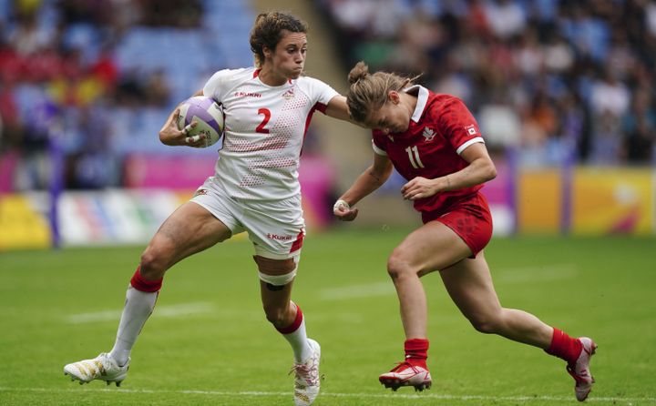 England's Abbie Brown, left, is tackled by Canada's Piper Logan during the Women's Pool A Rugby Sevens match at Coventry Stadium on day one of the 2022 Commonwealth Games in Coventry, England, Friday July 29, 2022. 