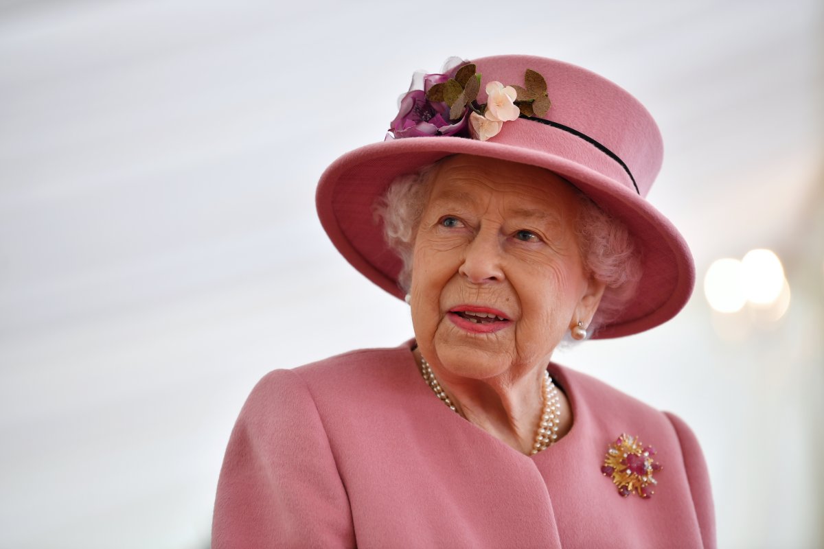 Queen Elizabeth II appears in a pink suit and hat.