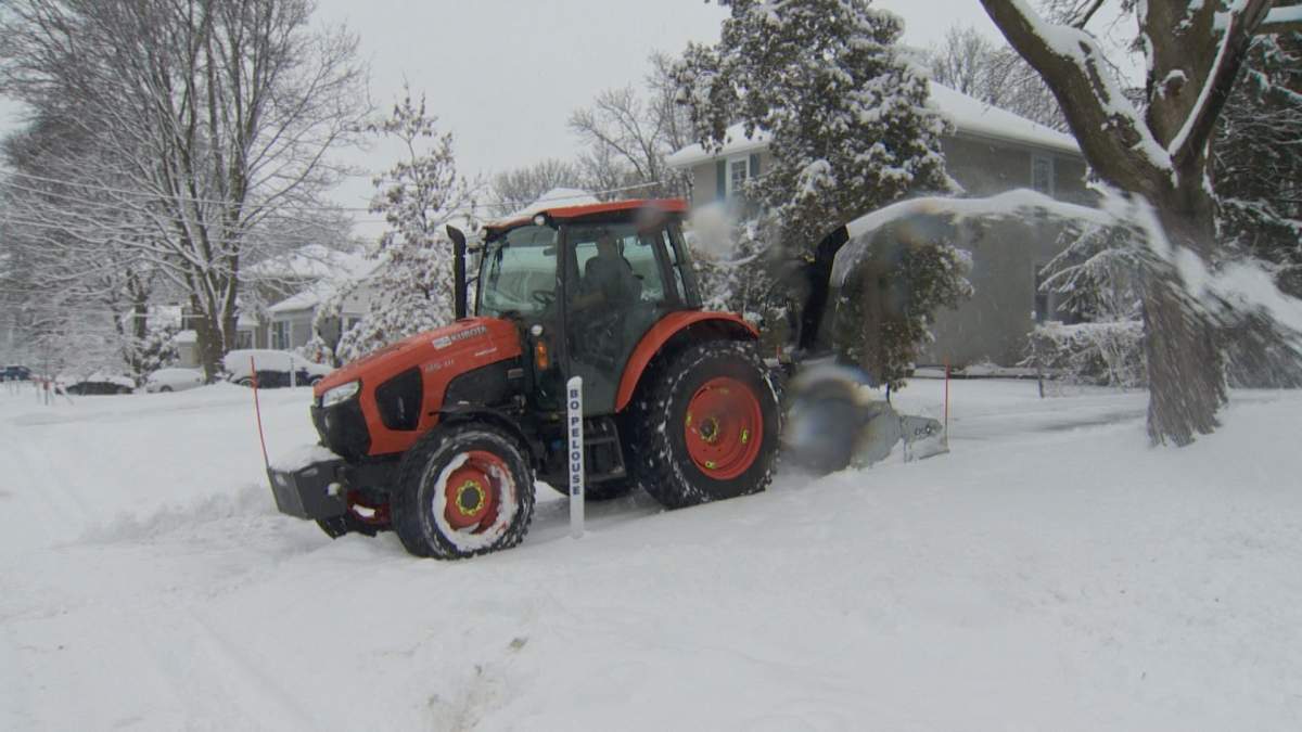 FILE. A snow removal company clears driveway . 