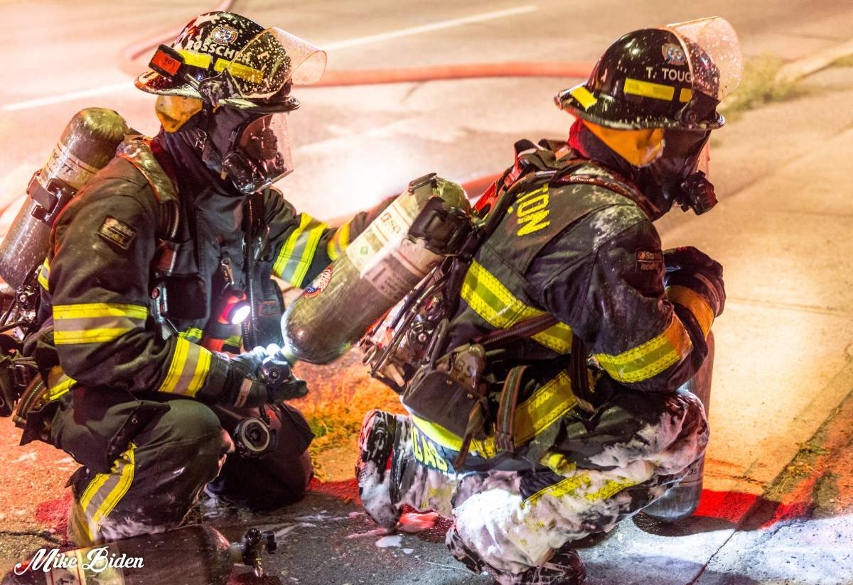 Two Penticton firefighters battling a structure fire on Skaha Lake Road in August. 
