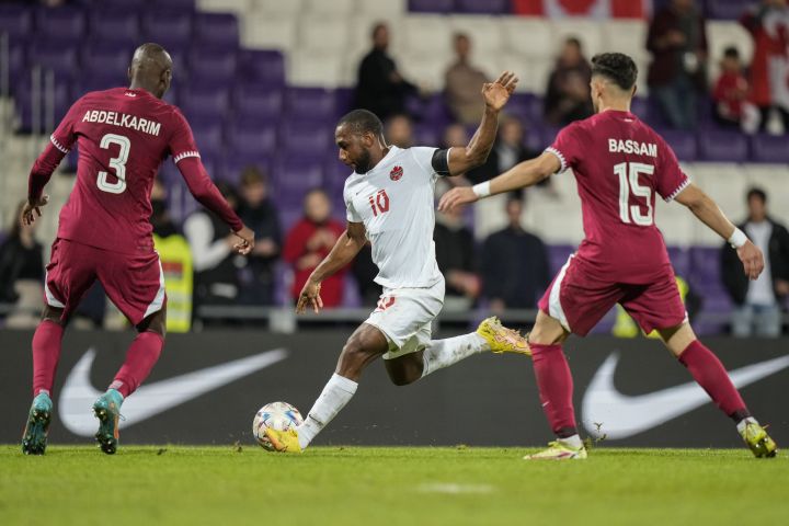 Canada's Junior Hoilett, runs for the ball behind Qatar players during the international friendly soccer match between Qatar and Canada, at the Viola Park stadium in Vienna, Austria, Friday, Sept. 23, 2022. 