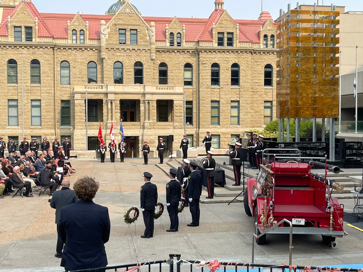 Members of the Calgary Fire Department and Calgary City Council gather in front of city hall to remember two fallen colleagues, on Sep. 13, 2022.