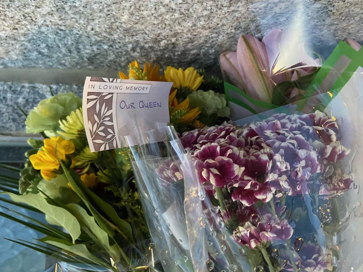 Flowers seen on the steps of the Alberta Legislature on Sept. 9, 2022 pay tribute to the late Queen Elizabeth the II after she died on Thursday.