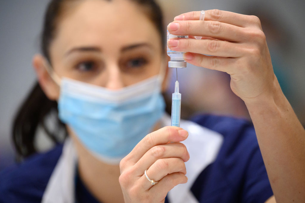 FILE - Medical staff and volunteers prepare shots of the Moderna vaccine.