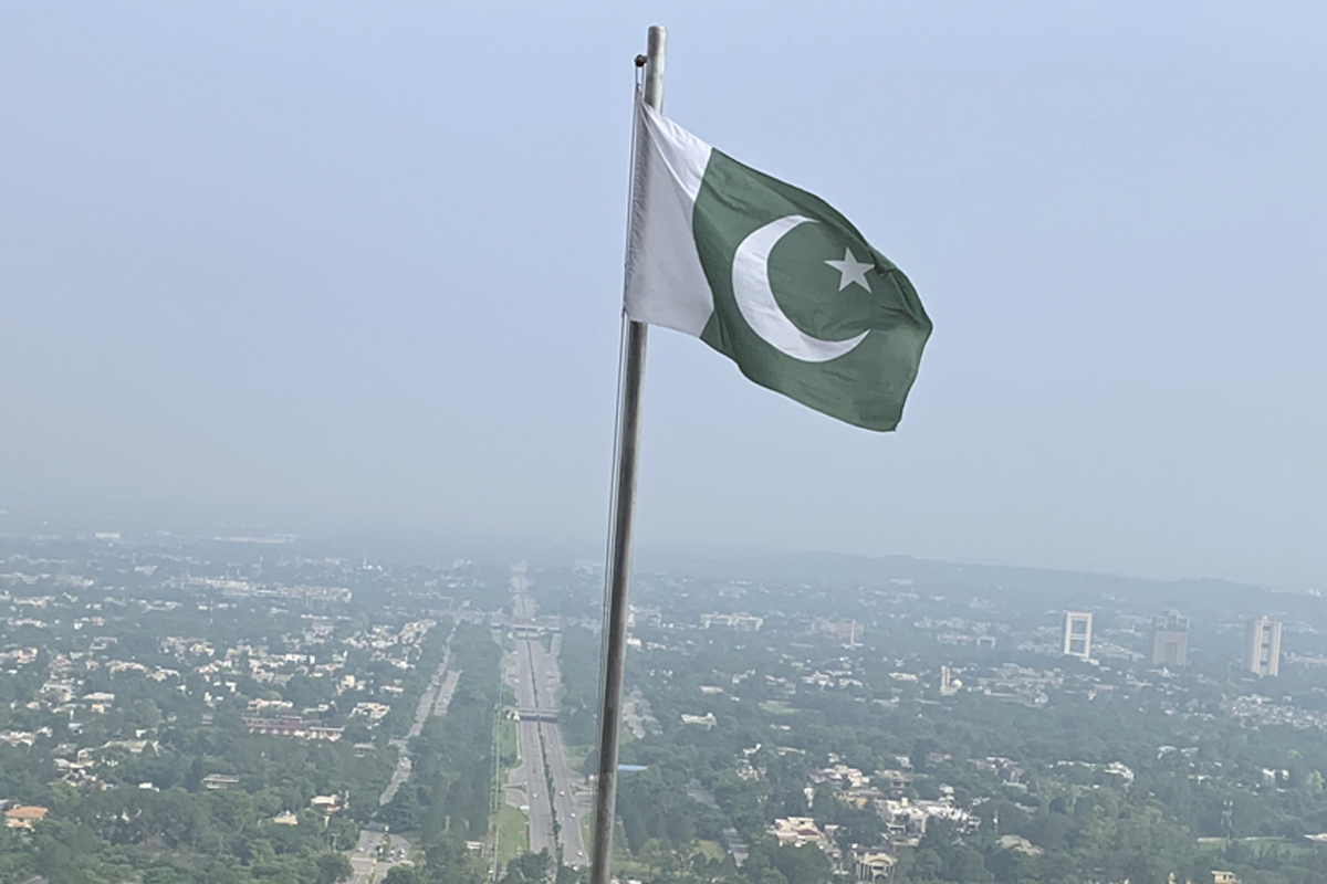 A Pakistani flag flies on a lookout in front of Islamabad, Pakistan, Wednesday, July 27, 2022. 