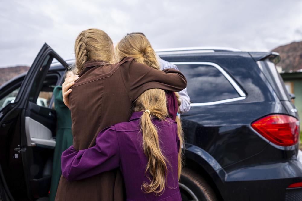 Three girls embrace before they are removed from the home of Samuel Bateman, following his arrest in Colorado City, Ariz.