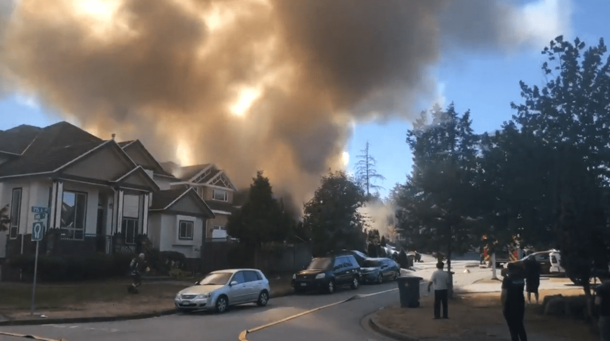 Smoke pours from a house on fire in Surrey on Monday. 