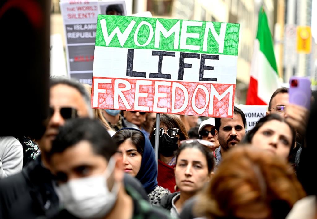 Protestors carry signs reading 'Women Life Freedom.'