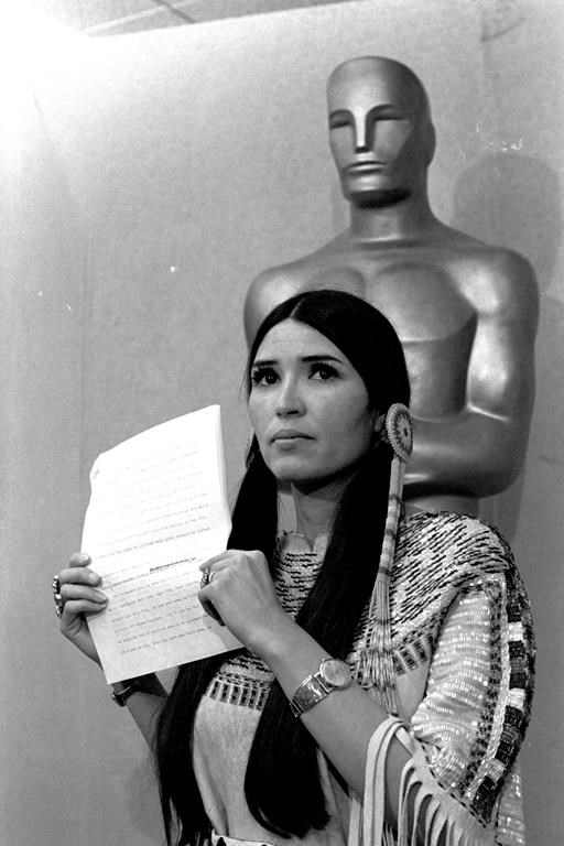 FILE - Sacheen Littlefeather, a Native American activist, tells the audience at the Academy Awards ceremony in Los Angeles, March 27, 1973, that Marlon Brando was declining to accept his Oscar as best actor for his role in "The Godfather." Sacheen Littlefeather died Sunday, Oct. 2, 2022, at her home in Marin County, Calif. She was 75.