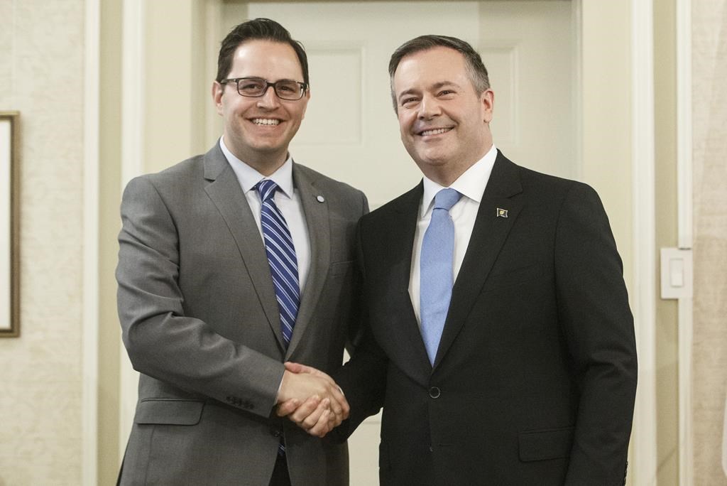 Alberta Premier Jason Kenney shakes hands with Demetrios Nicolaides, Minister of Advanced Education, after being sworn into office, in Edmonton on April 30, 2019. The Alberta government says it plans to spend $1 million to establish a non-profit organization that will work to attract more international students.