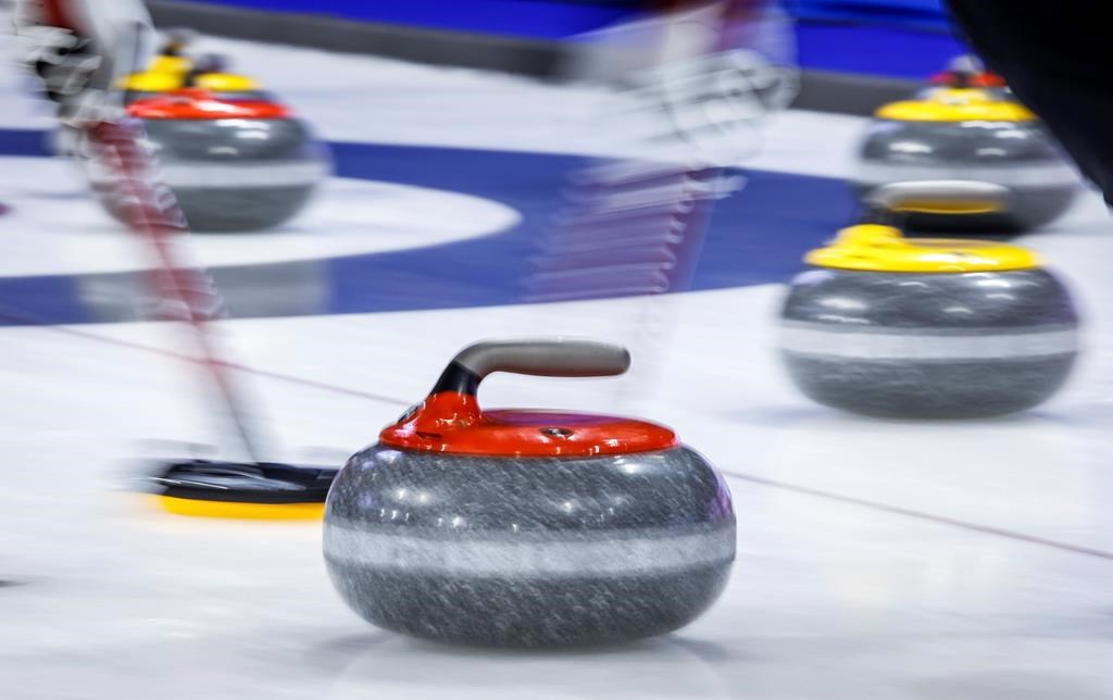 Players sweep a rock at the Tim Hortons Brier in Lethbridge, Alta. on March 6, 2022.