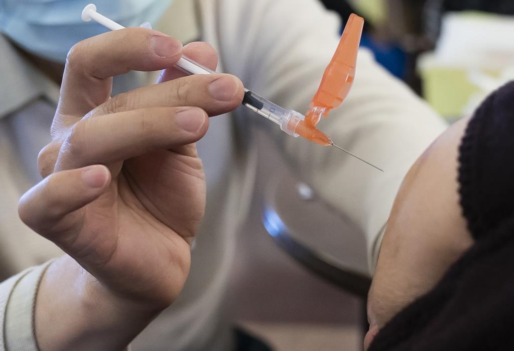 A person receives a COVID-19 vaccine at a vaccination clinic run by Vancouver Coastal Health, in Richmond, B.C., Saturday, April 10, 2021. Provincial officials say shipments of Pfizer's new COVID-19 vaccine targeting the Omicron variant are expected in British Columbia soon, after Health Canada approved the shot. THE CANADIAN PRESS/Jonathan Hayward.