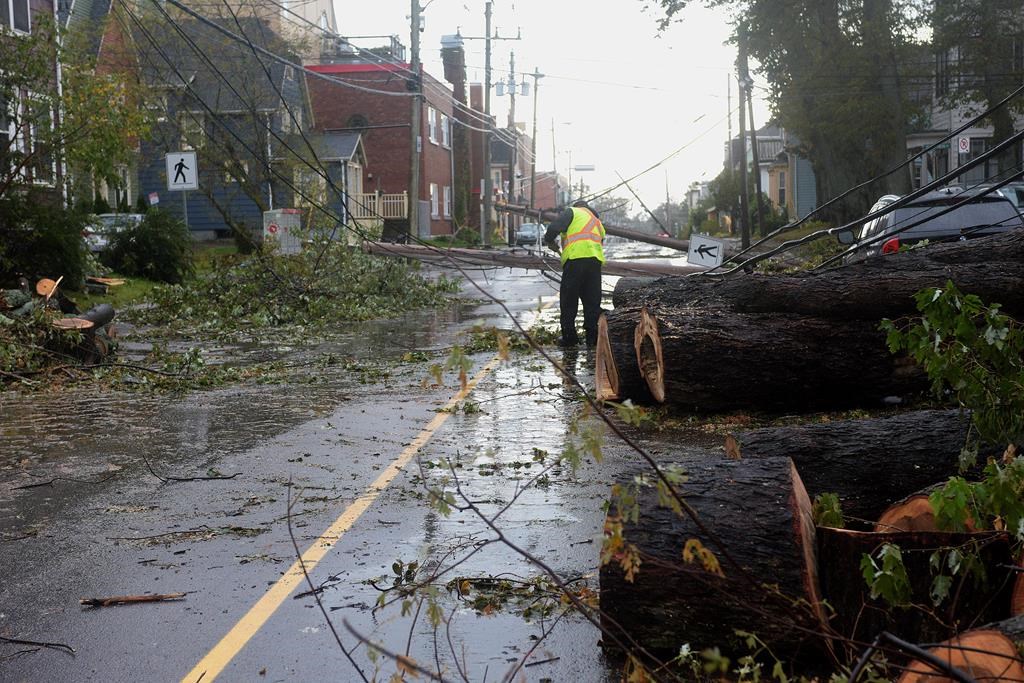 A worker begins the process of cleaning up after post-tropical storm Fiona, in Charlottetown, Monday, Sept. 26, 2022. .