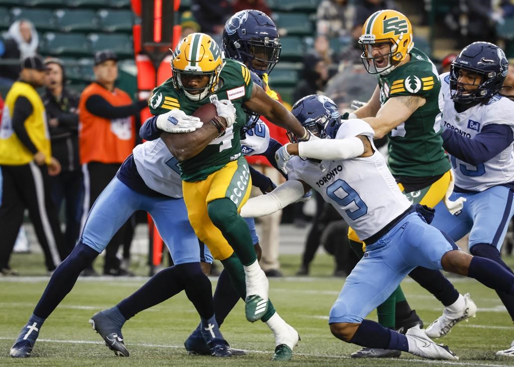 Toronto Argonauts' Royce Metchie, right, lets Edmonton Elks' Kevin Brown escape his grasp during first half CFL football action in Edmonton, Saturday, Oct. 15, 2022.