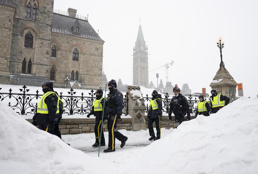 Police officers walk pass the Parliament buildings in Ottawa on Sunday, Feb. 20, 2022. Officials from the Ottawa Police Service and Ontario Provincial Police are expected to testify about their challenges overcoming the "Freedom Convoy" protests today at an inquiry investigating the federal government's use of the Emergencies Act.THE CANADIAN PRESS/Adrian Wyld.