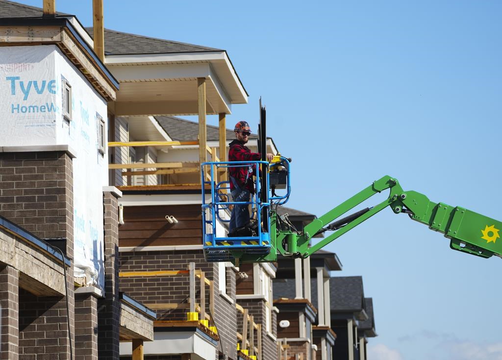 A construction worker works from a lift in a new housing development in Ottawa on Friday, Oct. 14, 2022. Ontario is planning to double the maximum fines for new homebuilders and sellers who unfairly cancel a project or purchase agreement. THE CANADIAN PRESS/Sean Kilpatrick.
