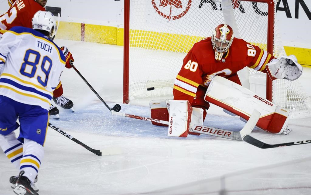 Buffalo Sabres forward Alex Tuch, left, scores on Calgary Flames goalie Dan Vladar during third period NHL hockey action in Calgary, Thursday, Oct. 20, 2022.