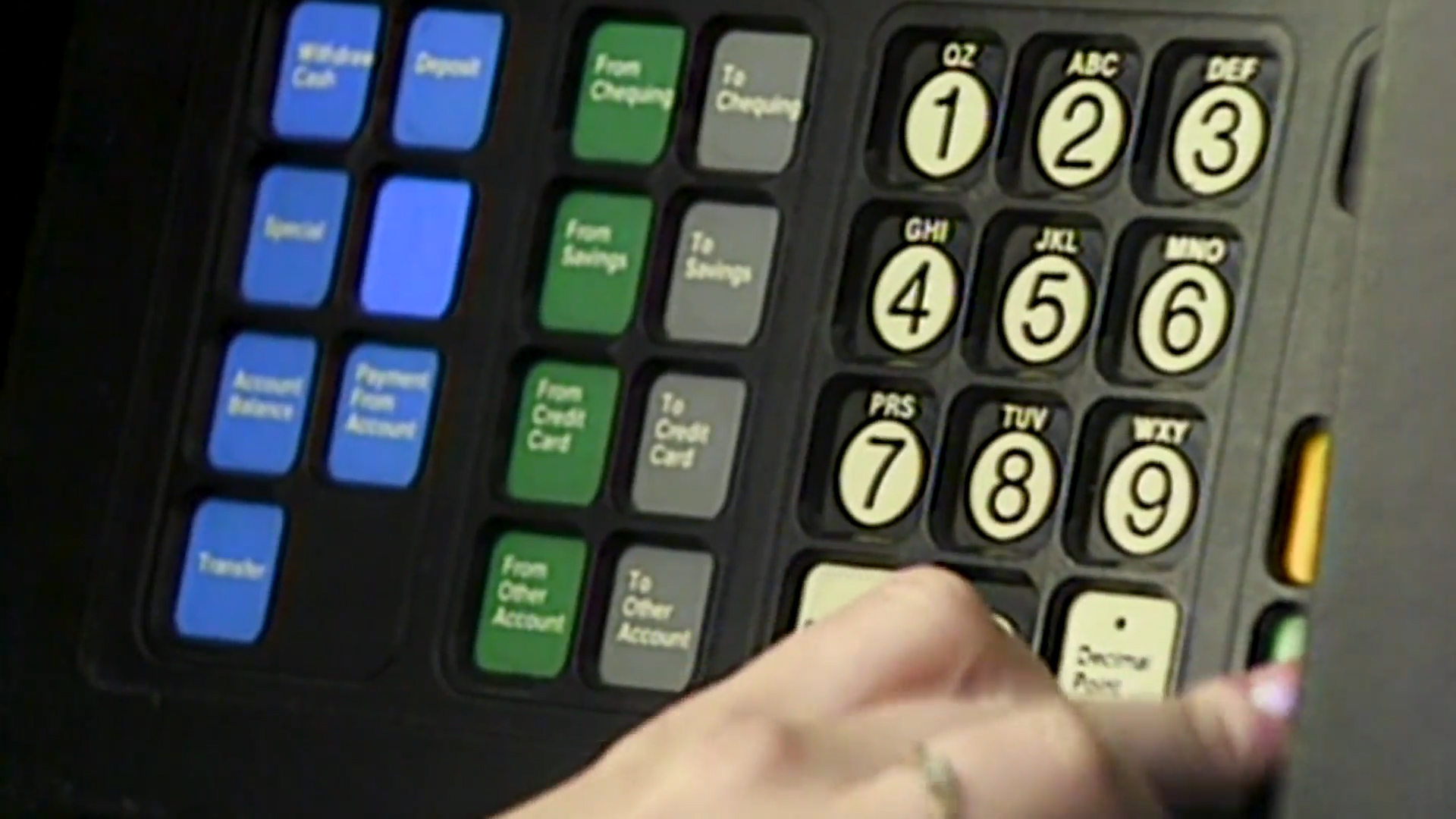 Someone using an automated banking machine in the 1980s