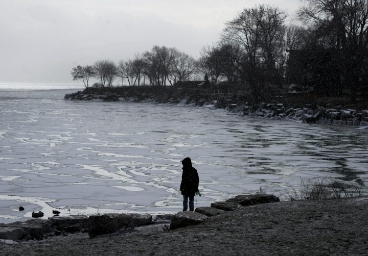 A man over looks an icy bay on Lake Ontario during a cold weather spell in Toronto, Tuesday, Jan. 11, .