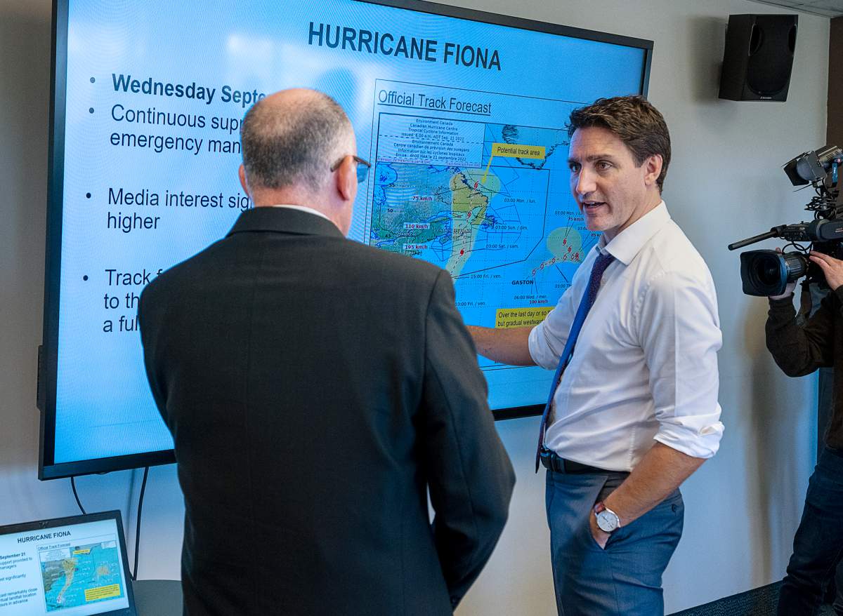 Prime Minister Justin Trudeau talks with Bob Robichaud, a meteorologist at the Canadian Hurricane Centre, in Dartmouth, N.S. on Tuesday, Oct. 4, 2022. Trudeau announced funding to support victims of post-tropical storm Fiona. THE CANADIAN PRESS/Andrew Vaughan