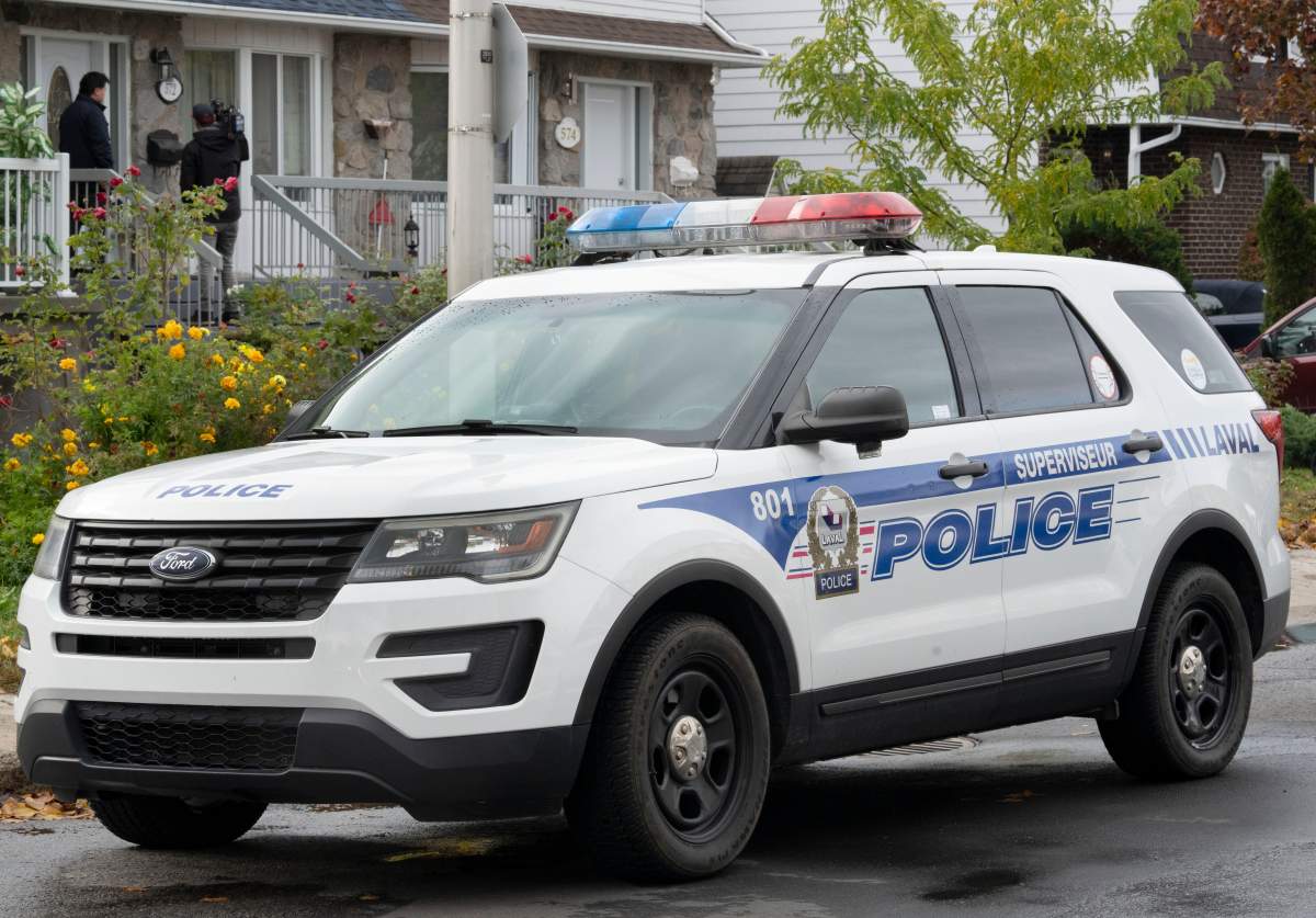 A police vehicle is shown outside a house in Laval, Que., Tuesday, Oct. 18, 2022.