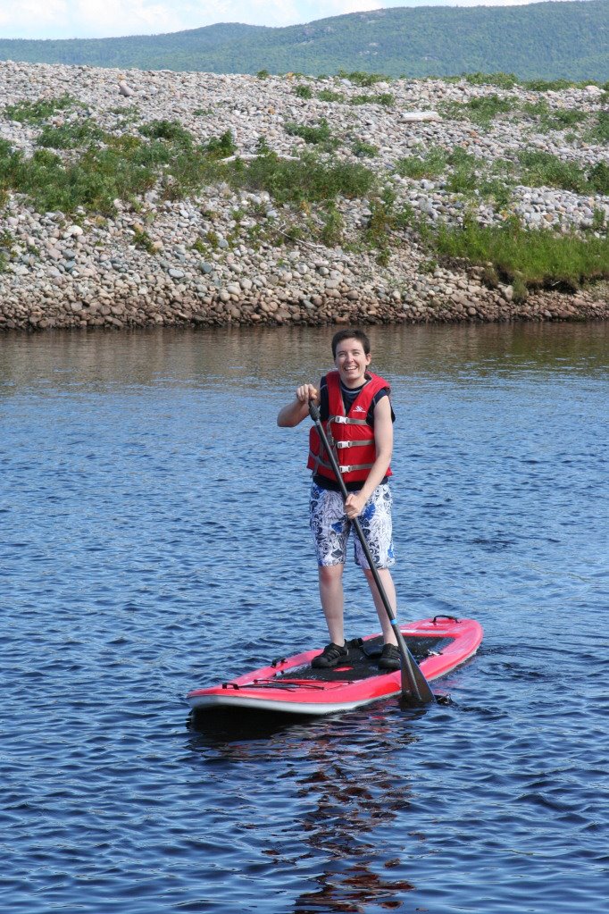 Declan Smith paddleboards during retreat for young cancer survivors.