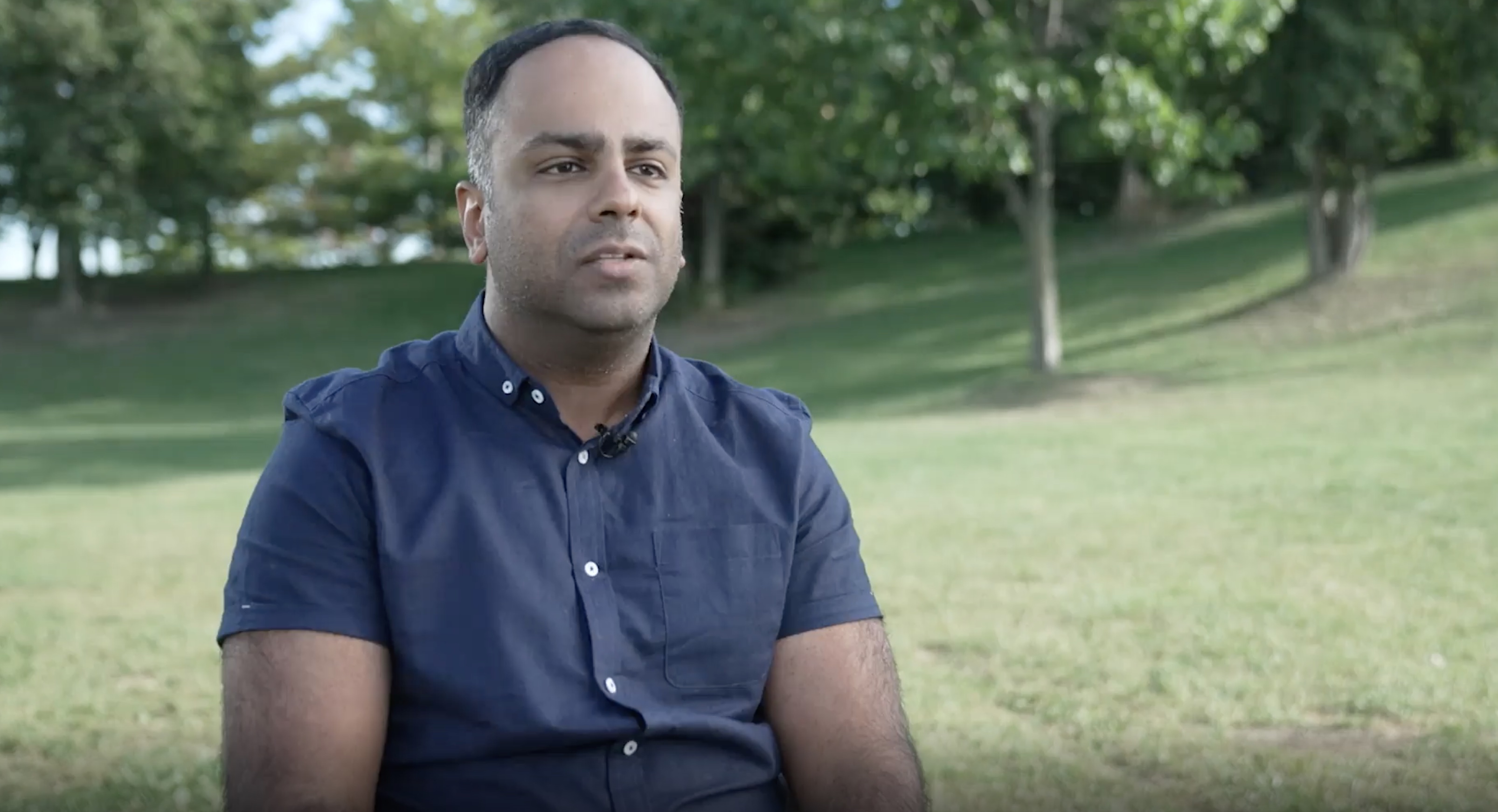 A man in a blue shirt in a park
