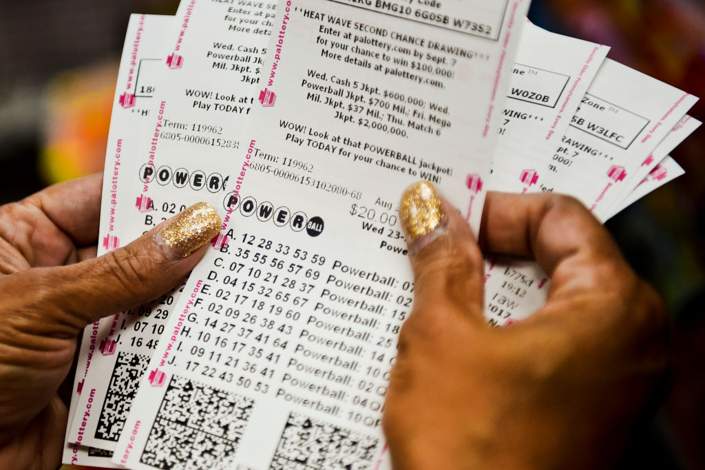File - A woman checks out her 126 Powerball tickets.