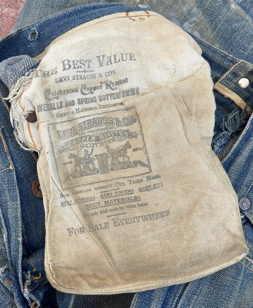The inside of the 1800s Levi's jeans. There is text printed on the inside pocket.