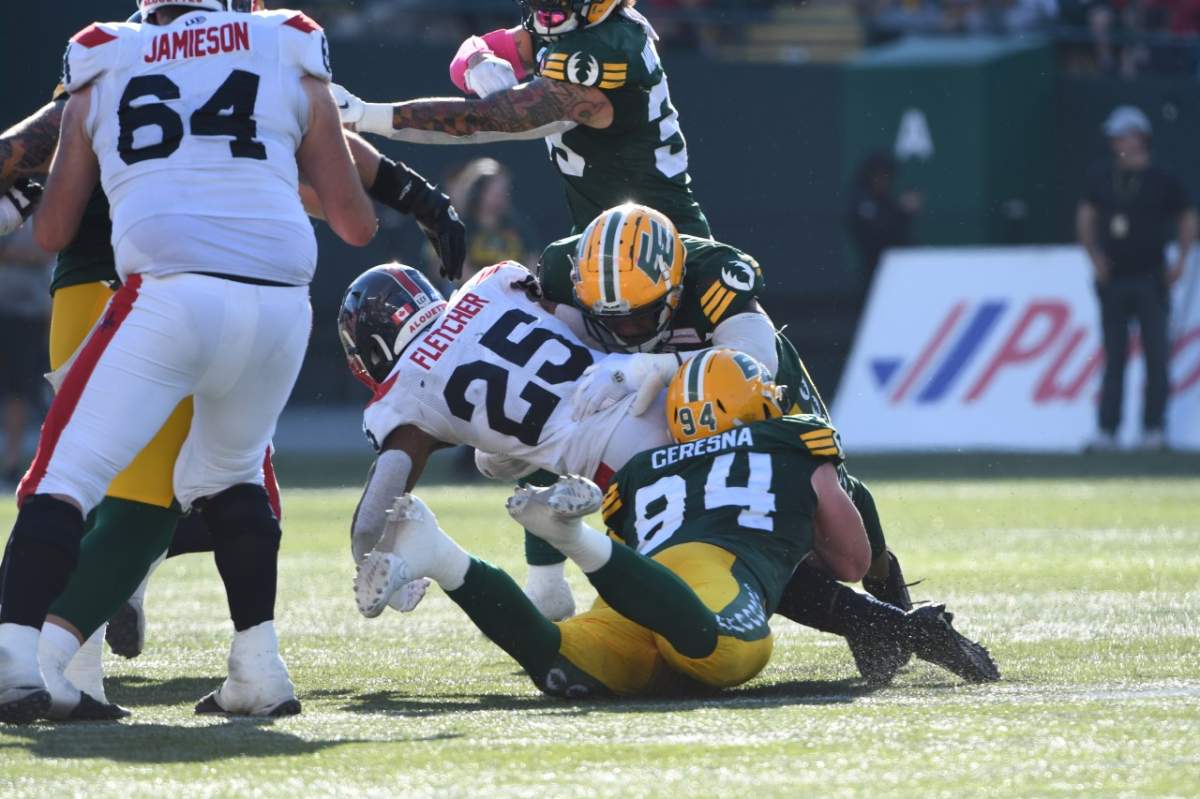 Elks defensive lineman Jake Ceresna tackles Alouettes running back Walter Fletcher