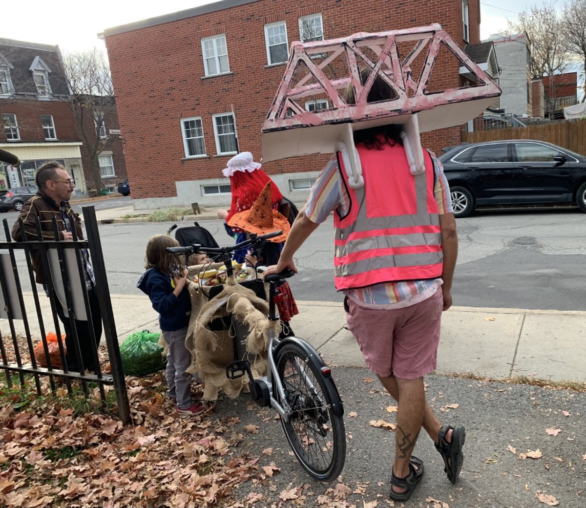 Mathieu Murphy-Perron dressed as a local bridge hands out candy to trick-or-treaters in Pointe-Saint-Charles while letting families try an e-cargo bike. October 31st, 2022.