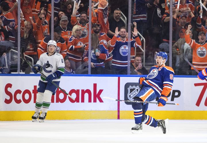 Vancouver Canucks’ Brock Boeser (6) looks on as Edmonton Oilers’ Connor McDavid (97) celebrates a goal during third period NHL action in Edmonton on Wednesday, October 12, 2022.