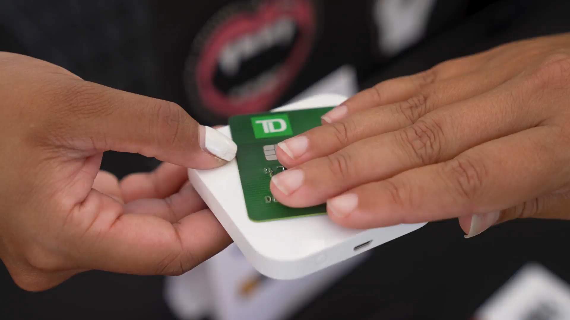 A person is using their debit card to pay for a purchase on a square reader