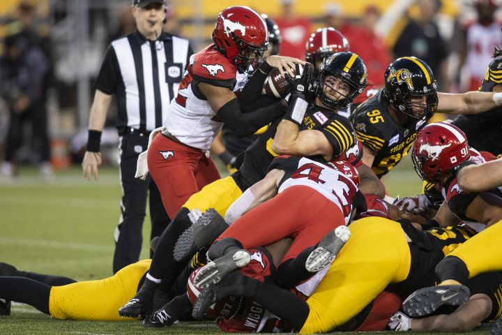 Hamilton Tiger-Cats quarterback Dave Evans (9) is stripped of the ball by Calgary Stampeders defensive back Titus Wall (32) during second half CFL football action in Hamilton on Saturday, June 18, 2022. 