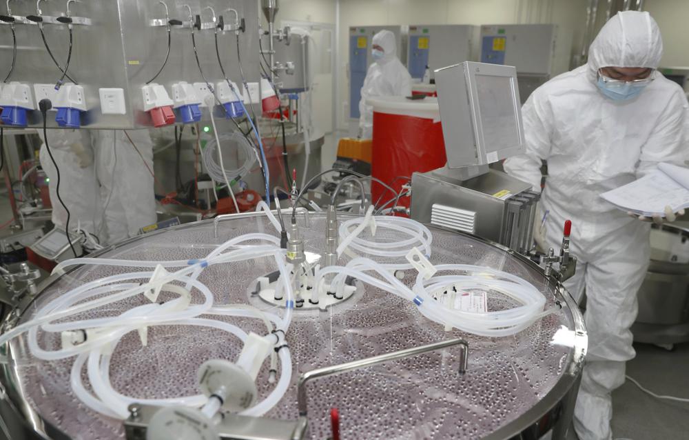 An employee in a white protective suit works on the production of the recombinant novel coronavirus vaccine (adenovirus Type 5 vector or Convidecia).