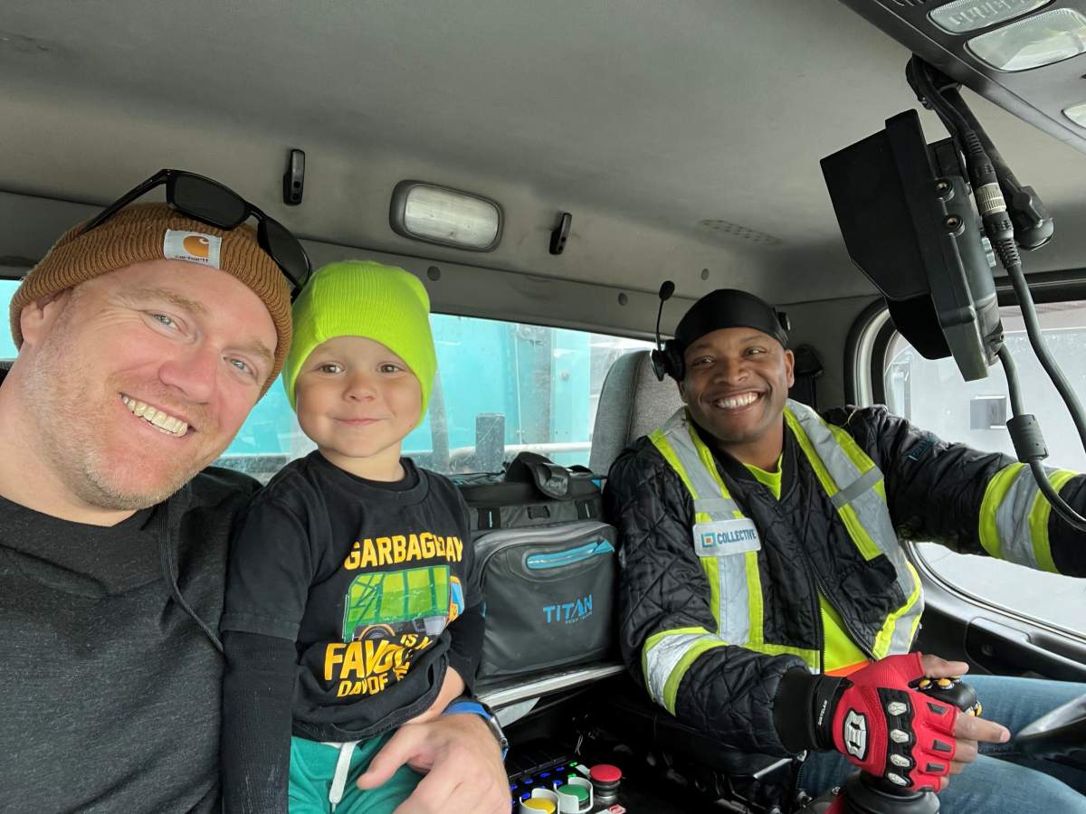 Nolan, his dad Brian and Clint inside the garbage truck.