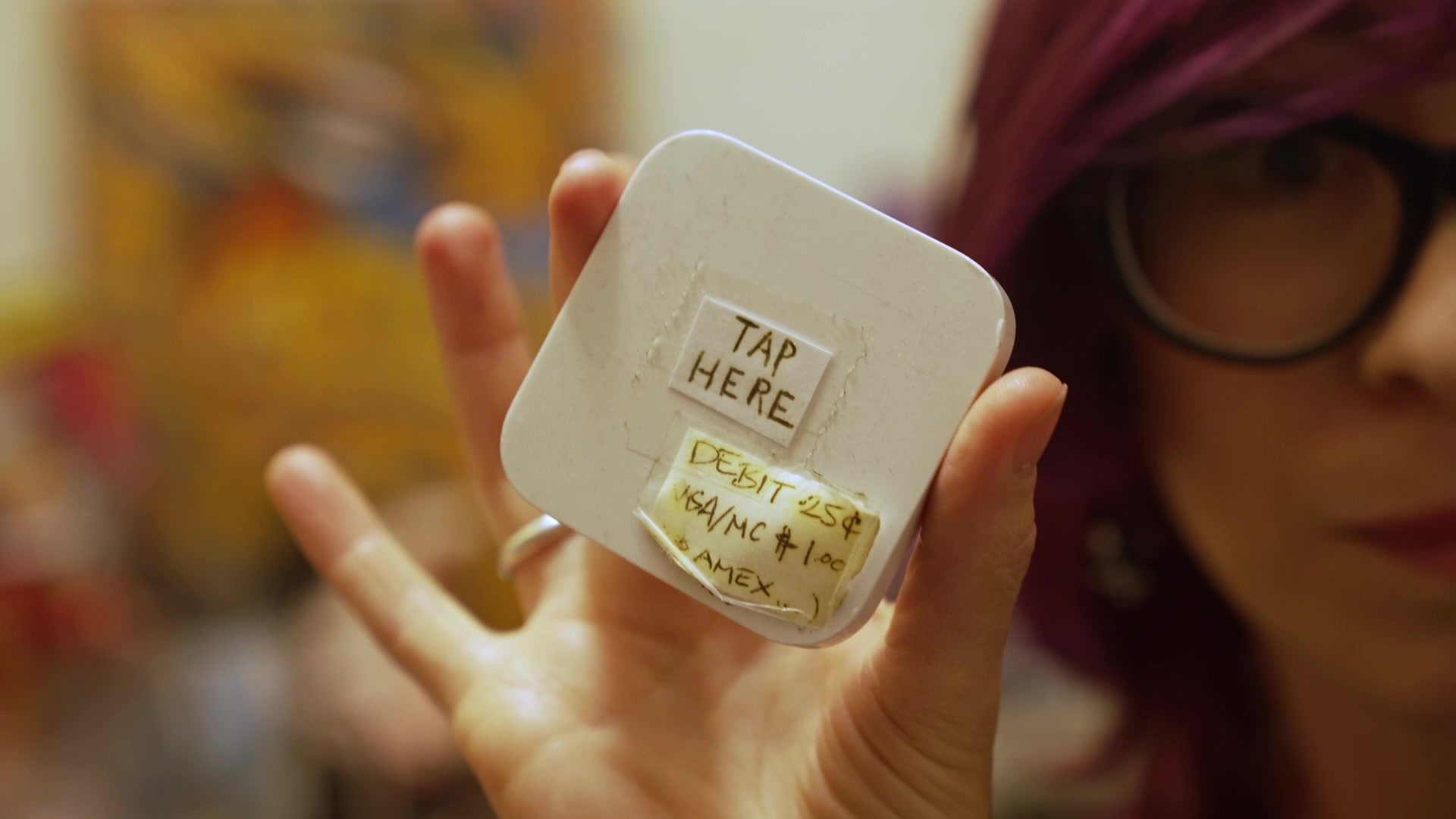 Abra holding up the square reader she used during the pandemic.