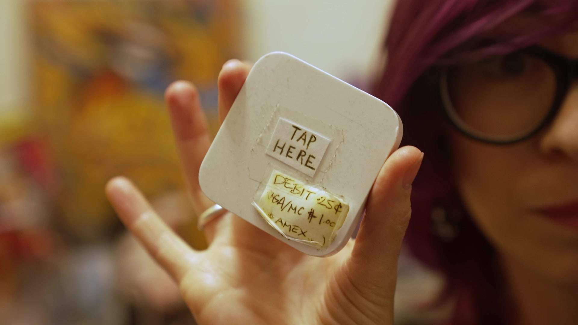 Abra holding up the square reader she used during the pandemic.