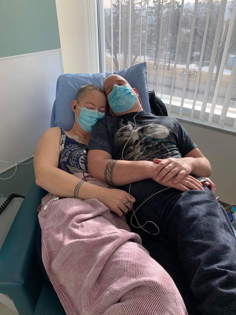 Hilary Boswell is pictured taking a rest with her partner while undergoing chemotherapy at the Tom Baker Cancer Centre in Calgary.
