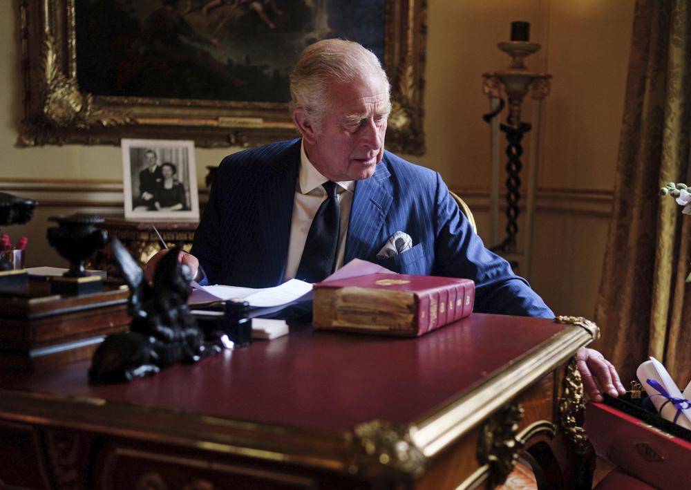 In this photo Sept. 11, 2022, taken Britain's King Charles III carries out official government duties from his red box in the Eighteenth Century Room at Buckingham Palace, London.